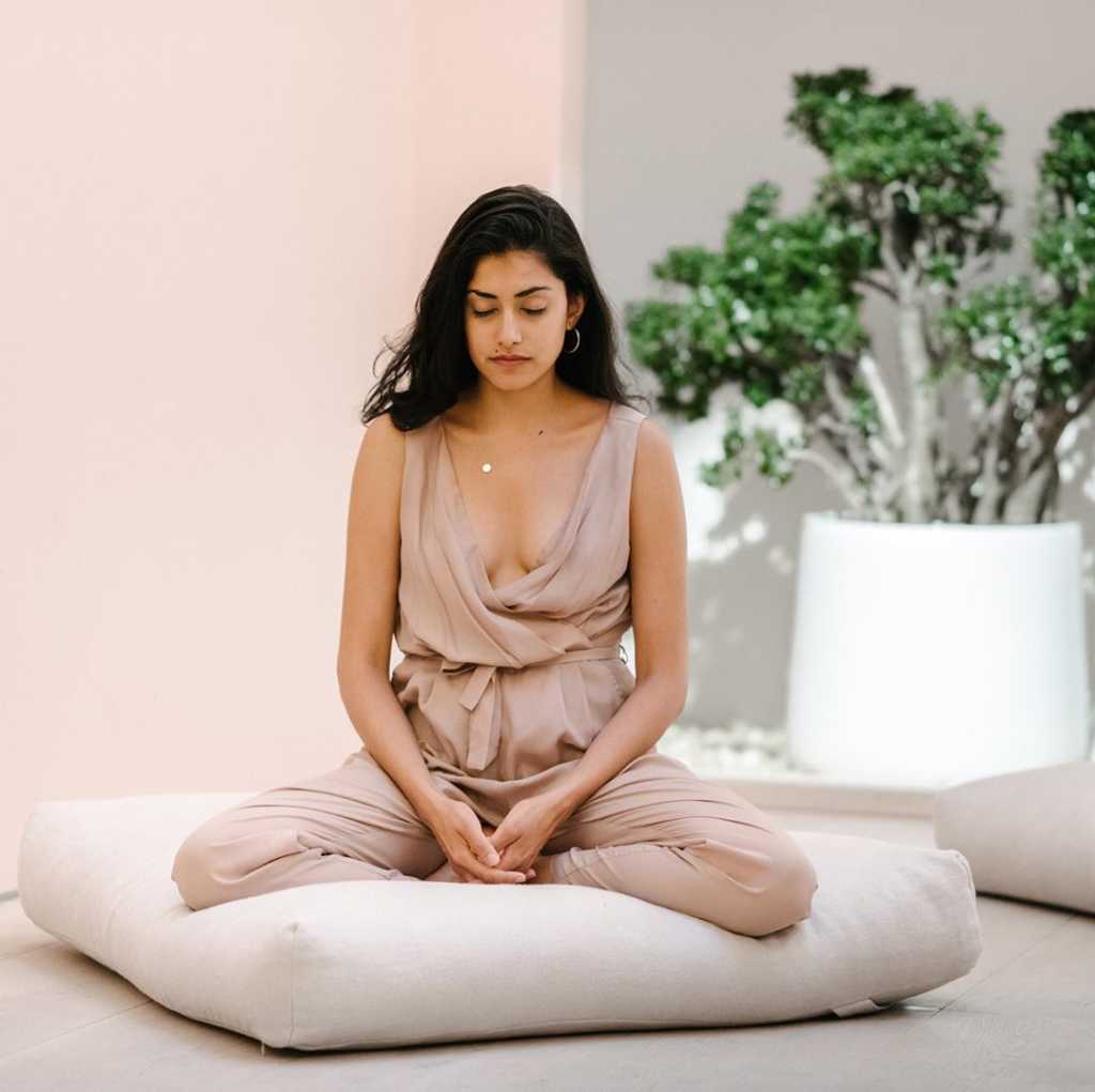 woman meditating on a cushion