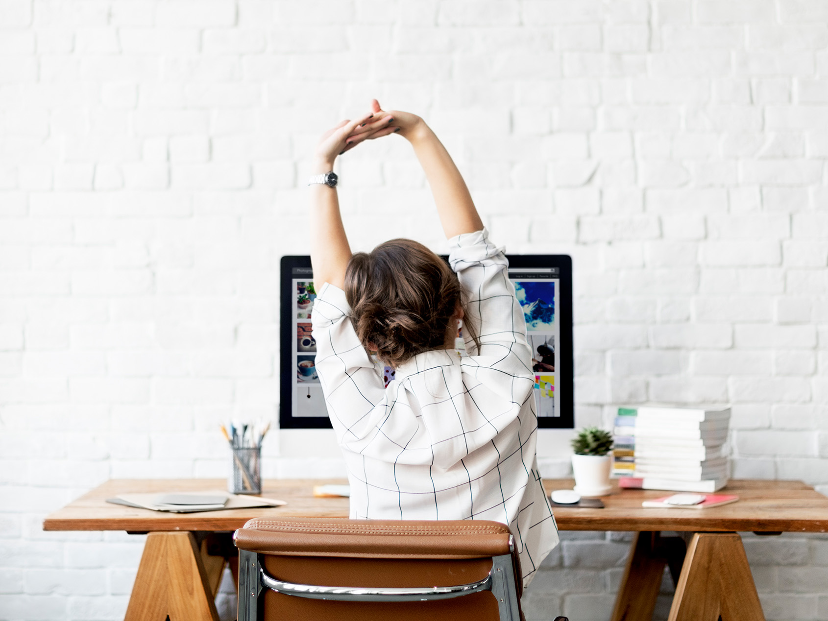 girl stretching arms at desk