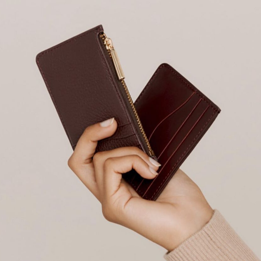 woman hand holding two small leather wallets