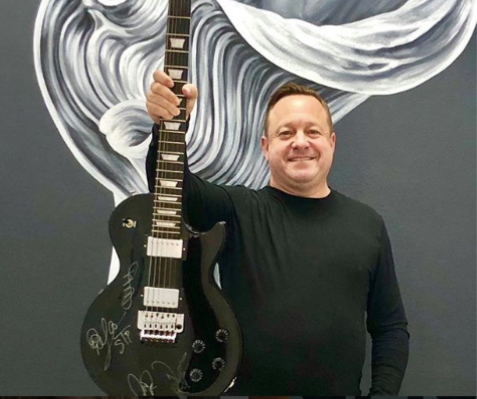 man in black shirt holding electric guitar 